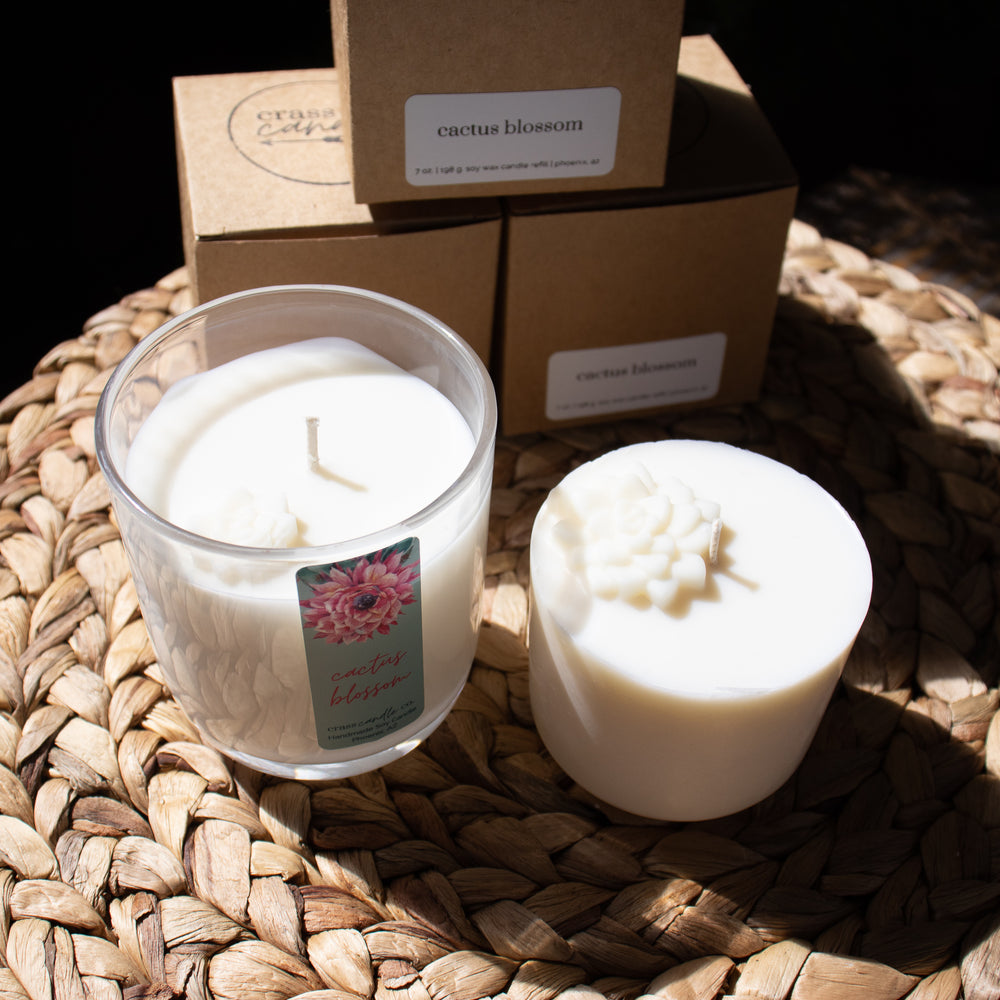 A molded white soy wax refill in front of the box it comes in and next to a full candle jar.